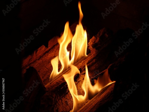  Hot orange flames from a burning log in a fireplace