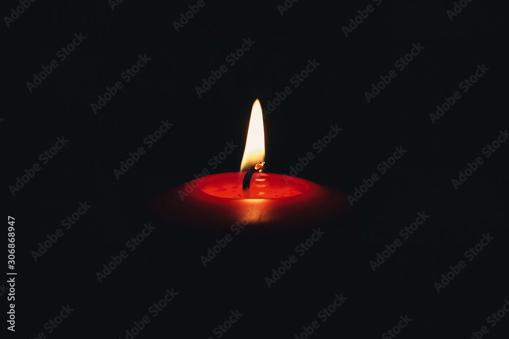 Red candle flame on a dark background Red candle flame on a dark background