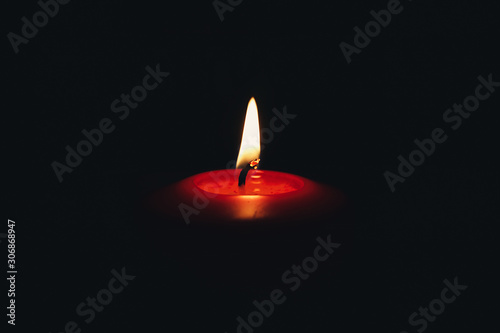 Red candle flame on a dark background