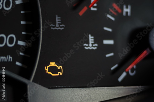 Tableau sur toile Yellow lit engine error sign on car dashboard close up