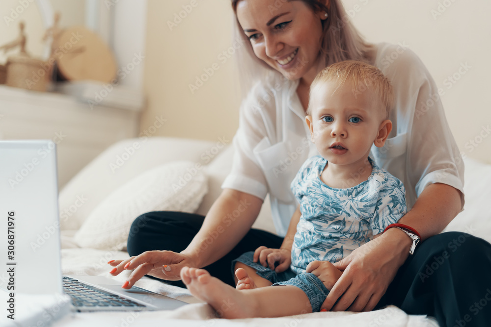 Modern woman working with child. Multi-tasking, freelance and motherhood concept Modern woman working with child. Multi-tasking, freelance and motherhood concept