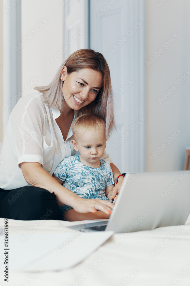 Modern woman working with child. Multi-tasking, freelance and motherhood concept Modern woman working with child. Multi-tasking, freelance and motherhood concept