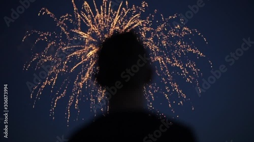 Blurred closeup silhouette of a man enjoying fireworks at night