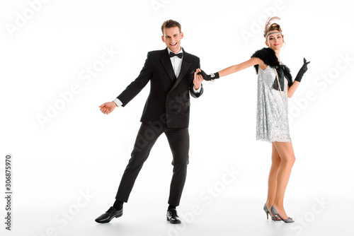 happy and stylish couple dancing isolated on white