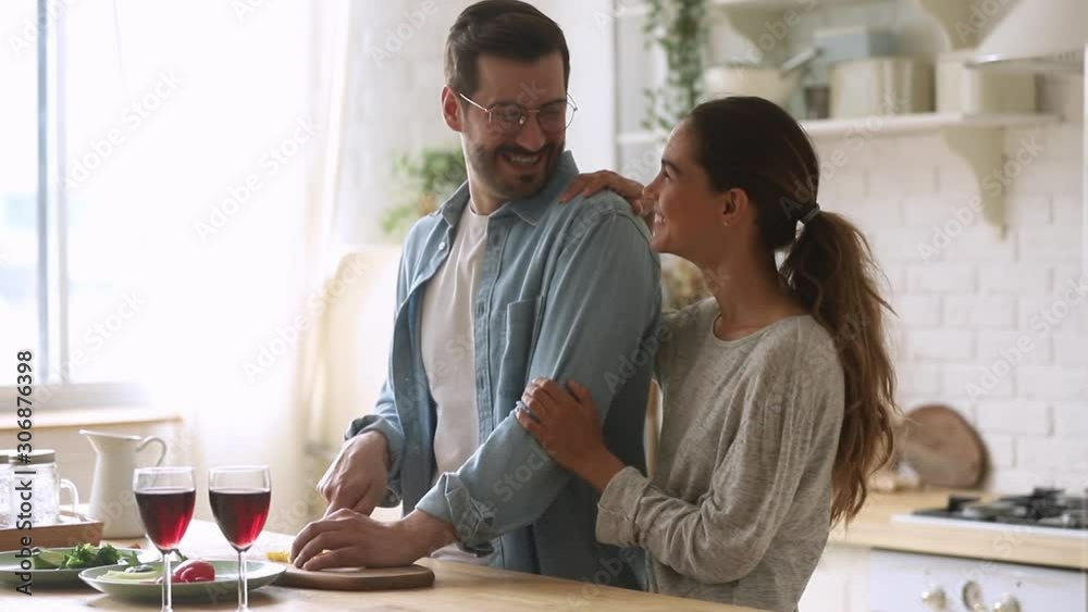 Cheerful young couple cook together prepare healthy meal in kitchen Cheerful young couple cook together prepare healthy meal in kitchen