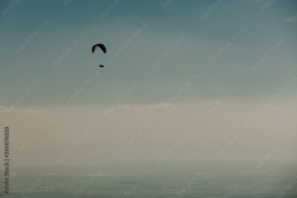 View of a paragliding in the sky. Paraglider flying over in The Nature Park Zumberak, Croatia View of a paragliding in the sky. Paraglider flying over in The Nature Park Zumberak, Croatia