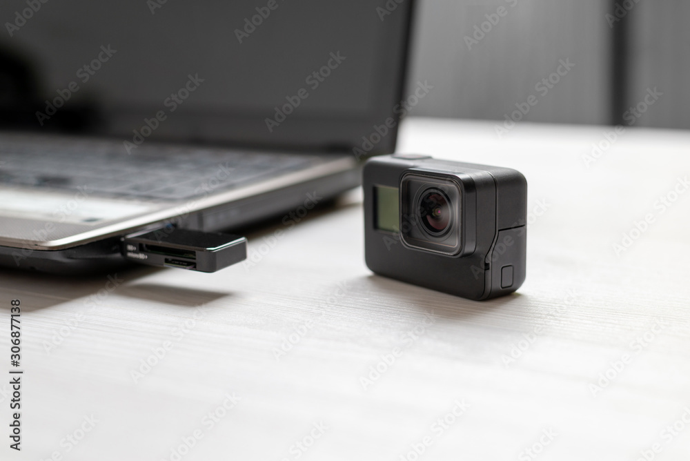Action camera next to the laptop. Mini SD card inserted in card reader on  usb port. The concept of transferring photos and videos to computer. foto  de Stock | Adobe Stock