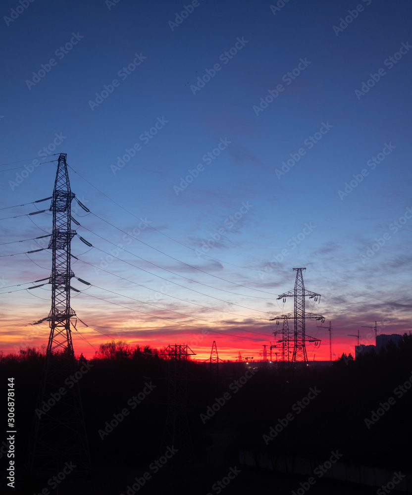 Power lines on a pink sky background. Sunrise over the forest