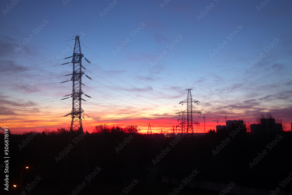 Power lines on a pink sky background. Sunrise over the forest