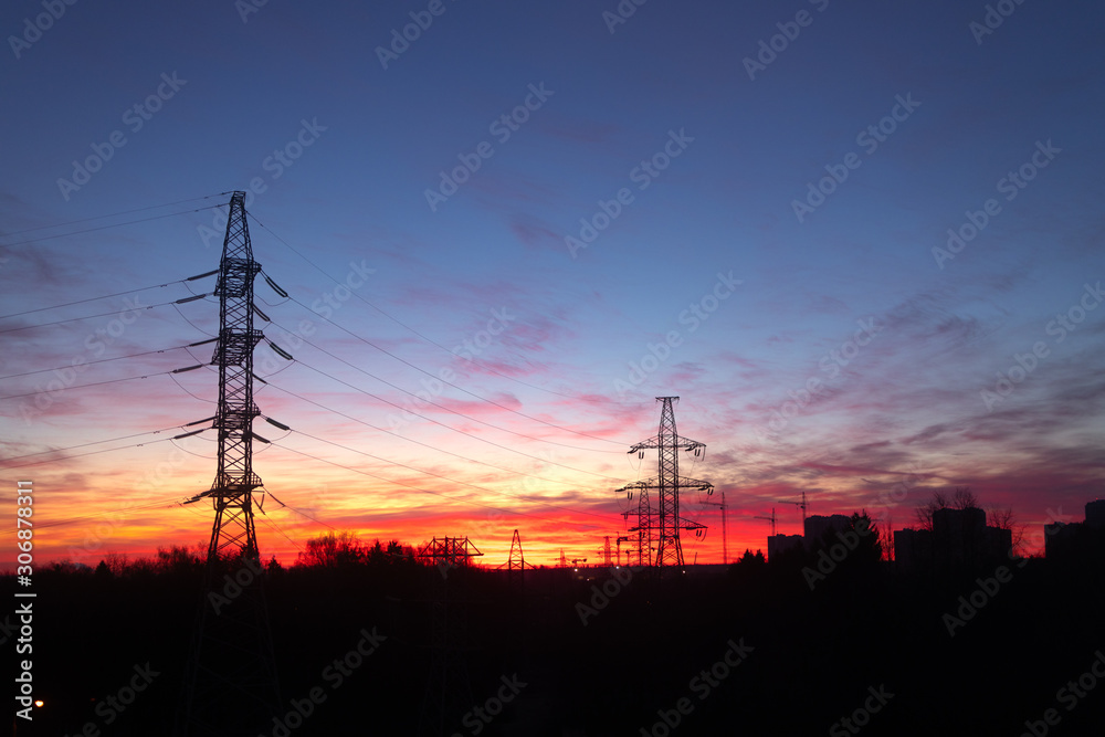 Power lines on a pink sky background. Sunrise over the forest