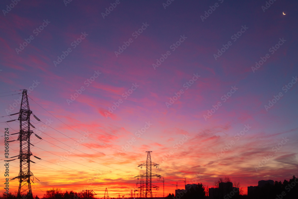 Fototapeta premium Power lines on a pink sky background. Sunrise over the forest