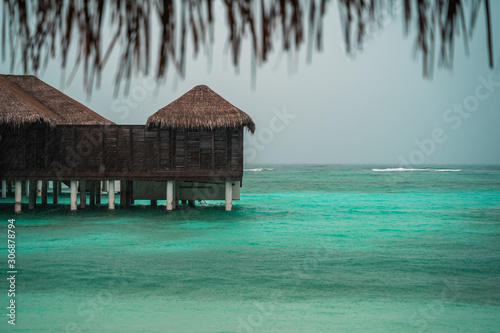 View of overwater bungalow beach villas in the Maldives on a rainy overcast day