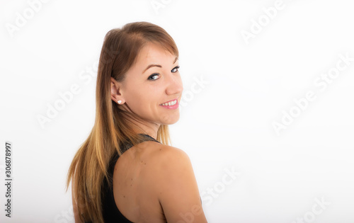 Close-up portrait of a young woman on a white background. Woman with face facing back