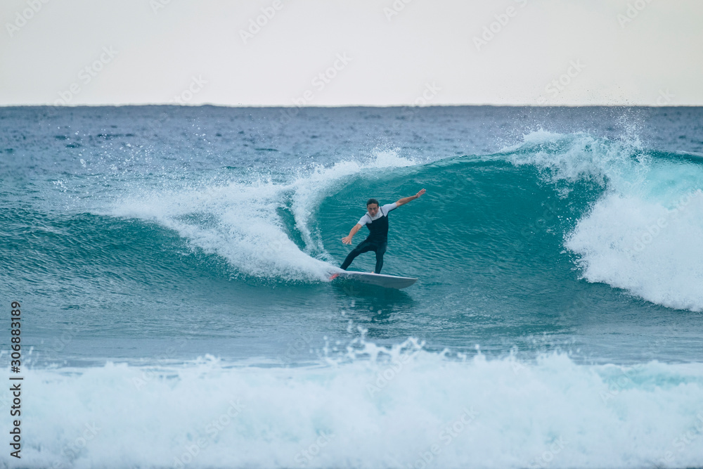 one man training and surfing in vacation in summer or winter using wetsuit - beautiful and big wave in canary island