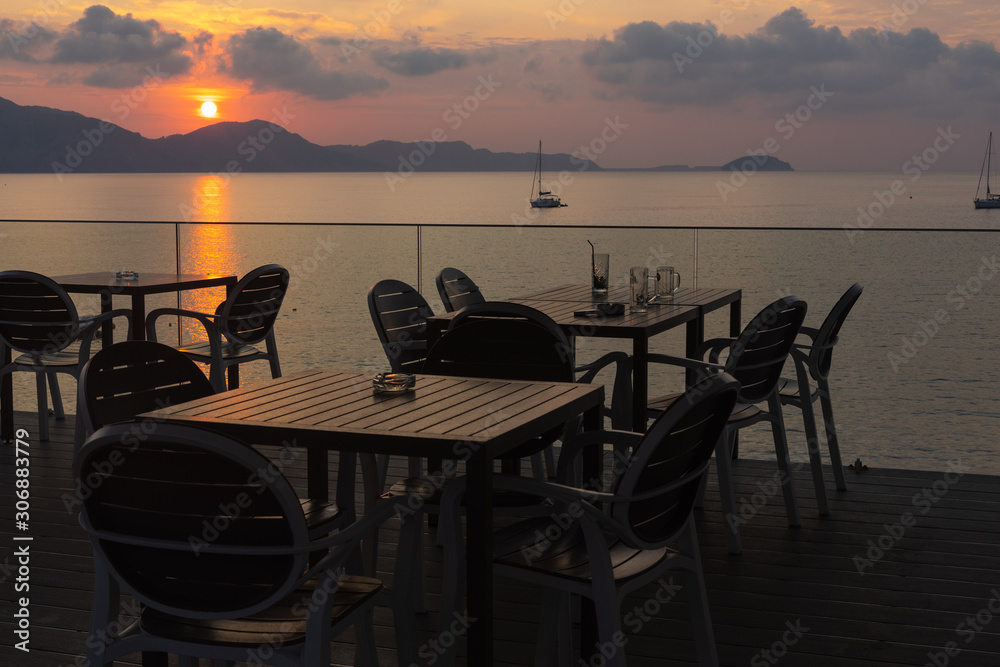 table in a cafe with chairs on a background of sunrise