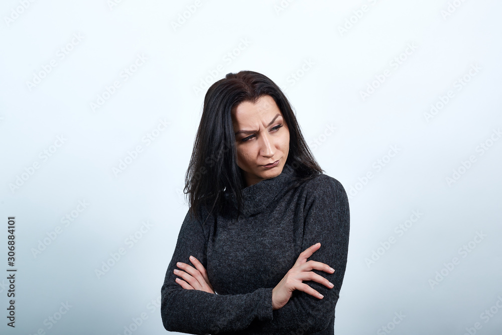 Beautiful caucasian young woman in fashion black sweater keeping hands crossed, looking serious over isolated white background, Lifestyle concept Beautiful caucasian young woman in fashion black sweater keeping hands crossed, looking serious over isolated white background, Lifestyle concept