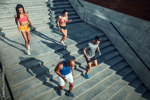 Athletic young people jogging on a stairs. © Alex