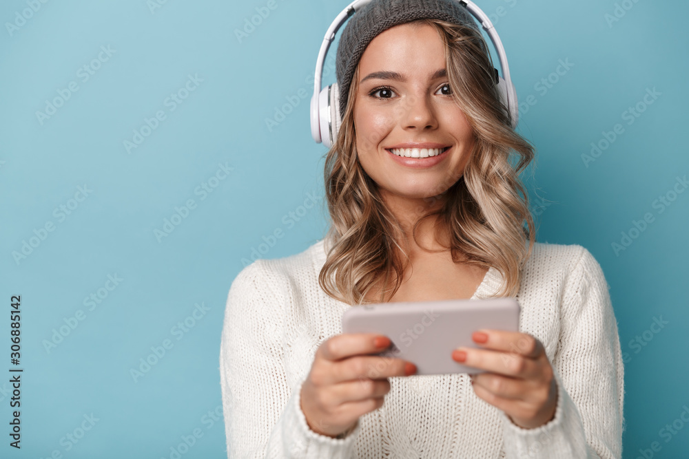 Portrait of nice joyful woman using headphones and cellphone Portrait of nice joyful woman using headphones and cellphone