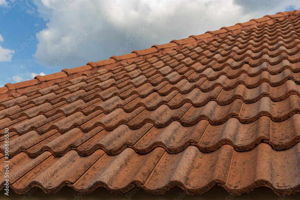 roof top on sky background. Close up of brown clay roof tiles. Red old dirty roof. Old roof tiles. Construction equipment build a house.