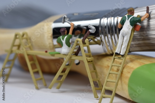 tiny painters are painting. Standing on a ladder, walking around brushes