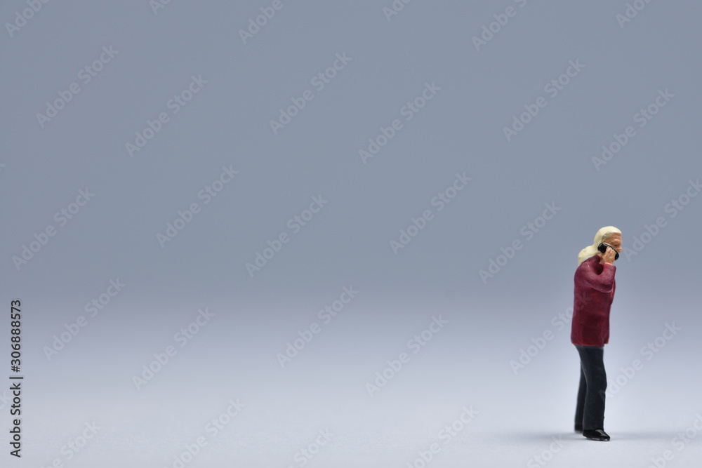 miniatuer figure man is talking on a cellular phone miniatuer figure man is talking on a cellular phone