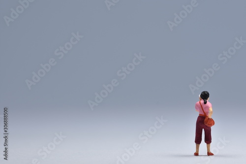 miniatuur woman standing is talking on a handy