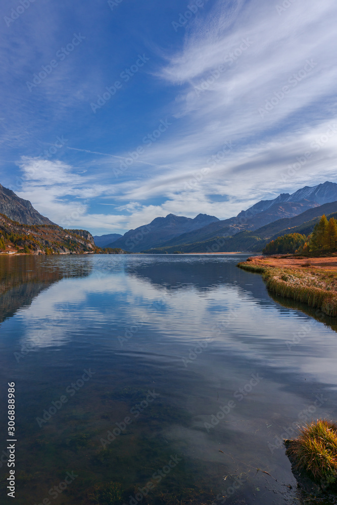 The Sils lake, the forest, the nature and the alps near the village of Maloja, Engadin, Switzerland - October 2019.