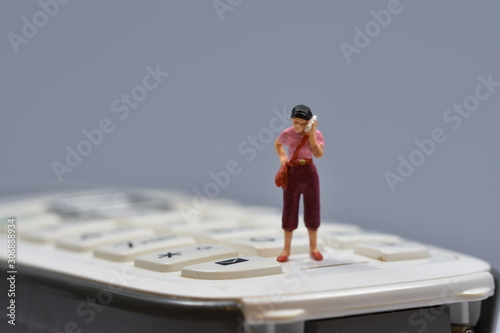 little woman is standing on a phone, talking on a cellular phone