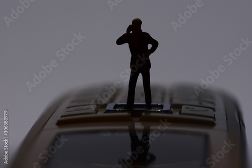 mini man talking on a mobile phone
