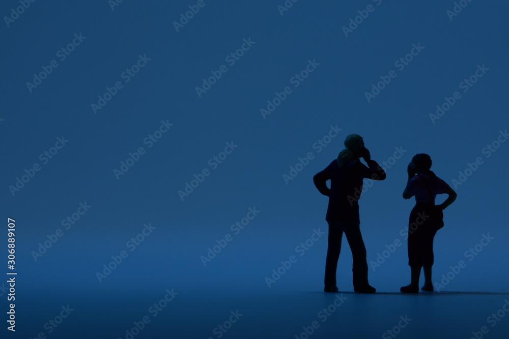 two tiny people talking on a smartphone two tiny people talking on a smartphone