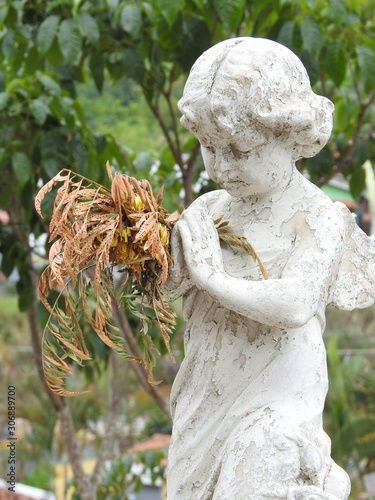 Fényképezés Scene in a cemetery: close-up of a stone statue of an angel praying with clasped hands