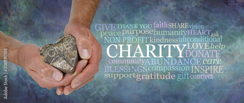 Heart Felt Charity Word Cloud - male hands holding a rustic wooden heart beside a CHARITY word cloud against a masculine grunge rustic stone effect petrol blue coloured background photo