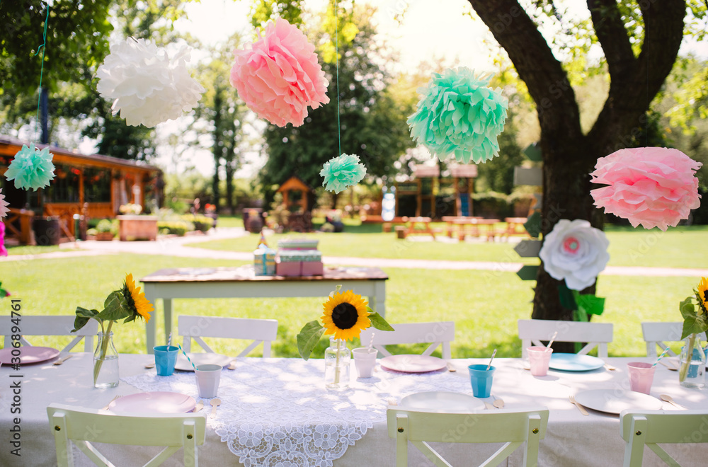 A table set for kids birthday party outdoors in garden in summer. - obrazy, fototapety, plakaty 