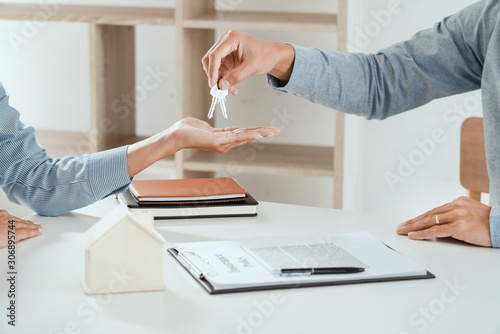 agent giving house keys to customer after sign agreement property, concerning mortgage loan offer for and house insurance.