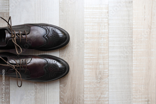 Modern trendy mans shoes are on floor on the left, view from the top. Place for the text.