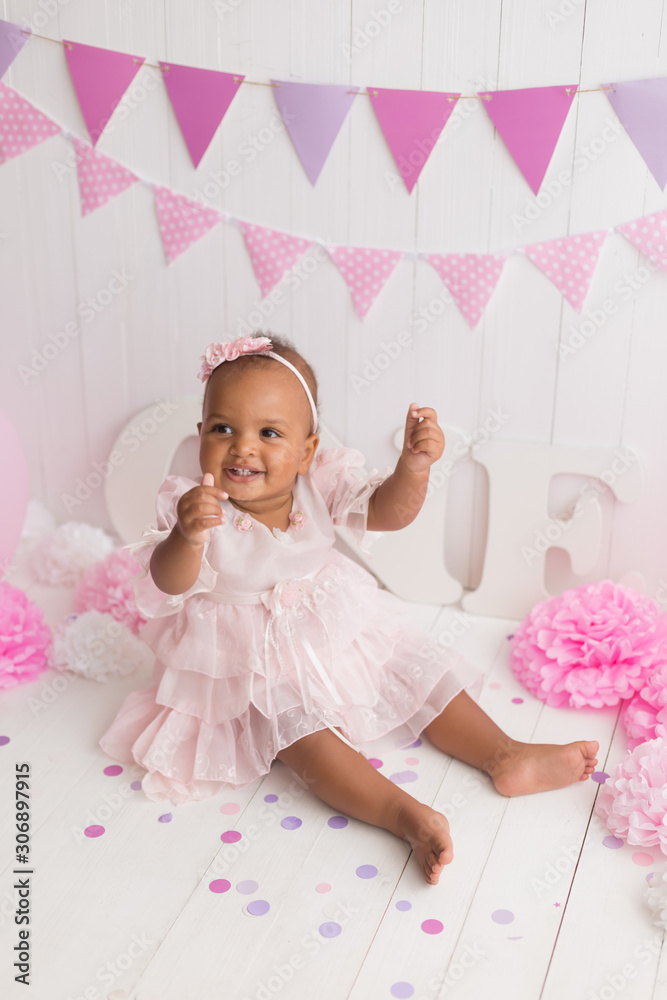 Fototapeta premium little girl black on white background. baby's first birthday
