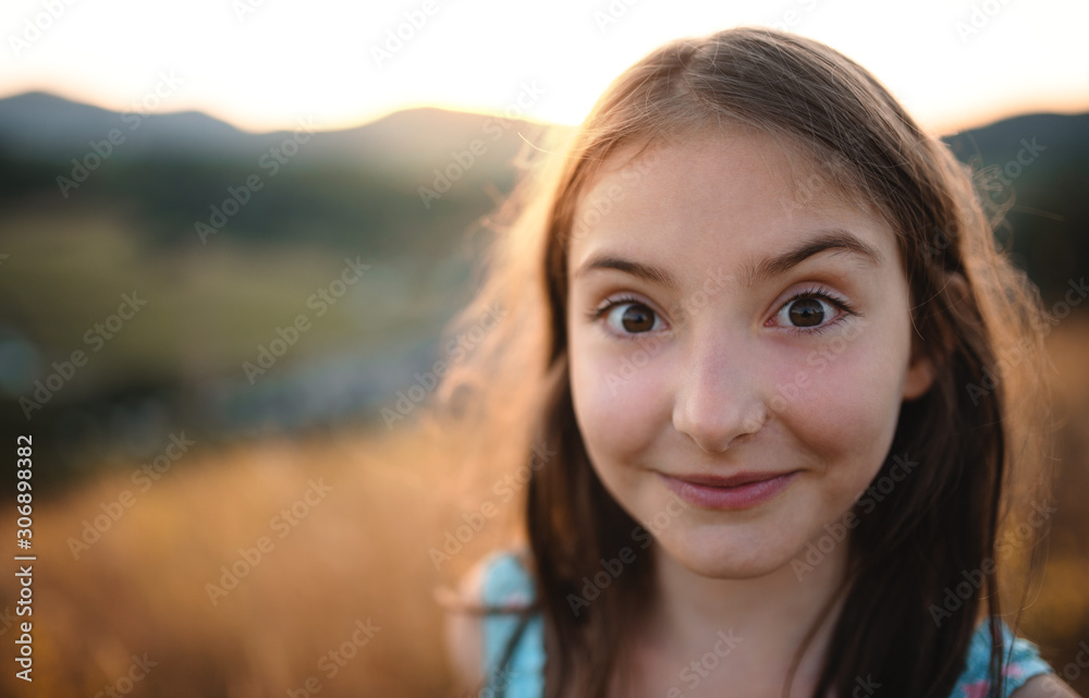 A portrait of small girl in in nature, looking at camera. A portrait of small girl in in nature, looking at camera.