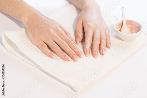 Beautiful woman hands applying pink clay mask