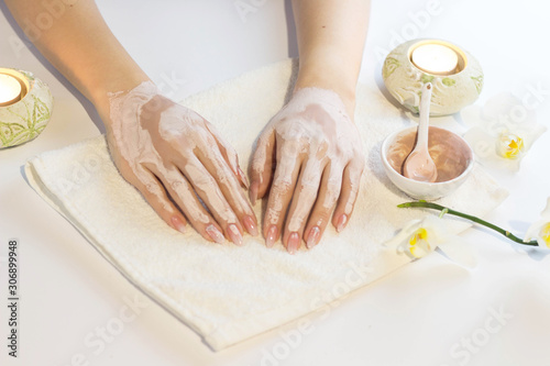 Beautiful woman hands applying pink clay mask