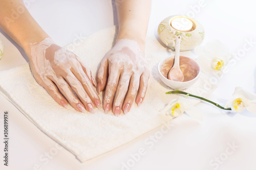 Beautiful woman hands applying pink clay mask