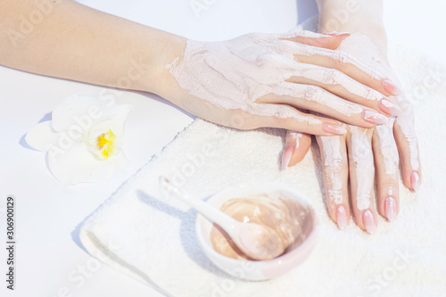 Beautiful woman hands applying pink clay mask