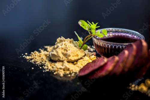 Face mask for a natural glow for all skin types on the black wooden surface consisting of some beetroot juice, yogurt, lime juice, and gram flour. Shot of face mask with entire ingredients.Horizontal  photo