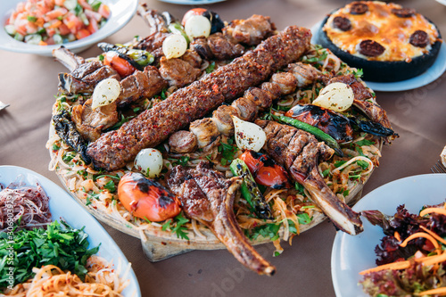 Traditional Turkish Adana kebab or kebap meat food, appetizers, raki and salgam on table from top view in turkish restaurant.	 photo
