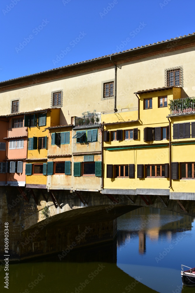 Ponte Vecchio and Arno River with blue sky. Colorful windows close-up. Florence, Italy.