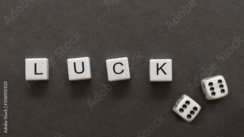 The inscription luck on a gray background with game cubes. View from above