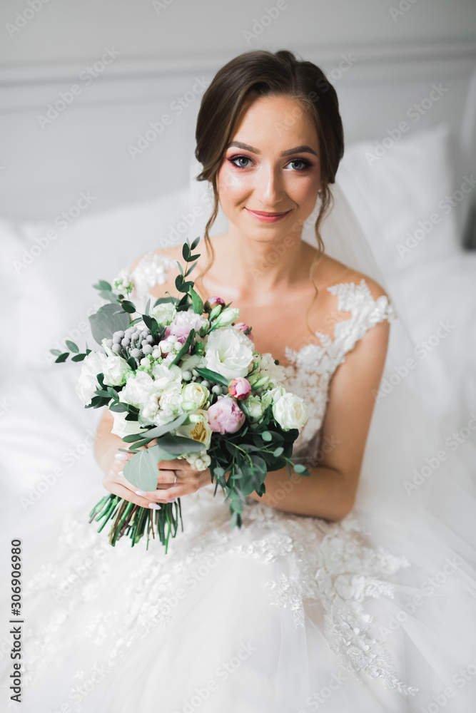 Naklejka premium Luxury wedding bride, girl posing and smiling with bouquet