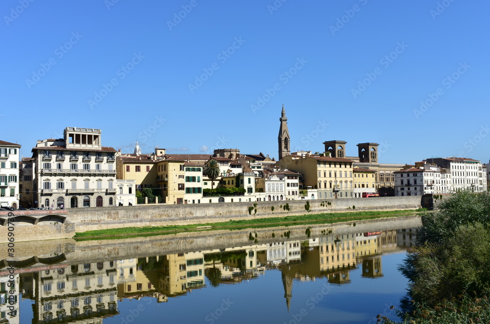 View of Arno River with Basilica di Santa Croce bell tower and water reflection. Florence, Italy.