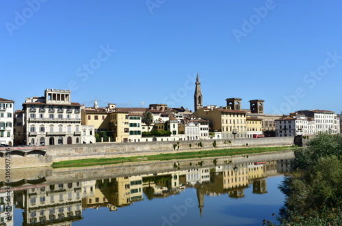 View of Arno River with Basilica di Santa Croce bell tower and water reflection. Florence, Italy.