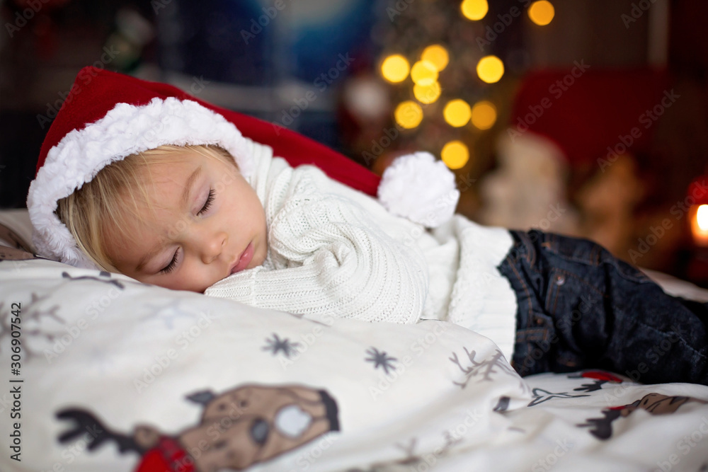 Sweet beautiful blond toddler boy, sleeping in bed with toy Sweet beautiful blond toddler boy, sleeping in bed with toy