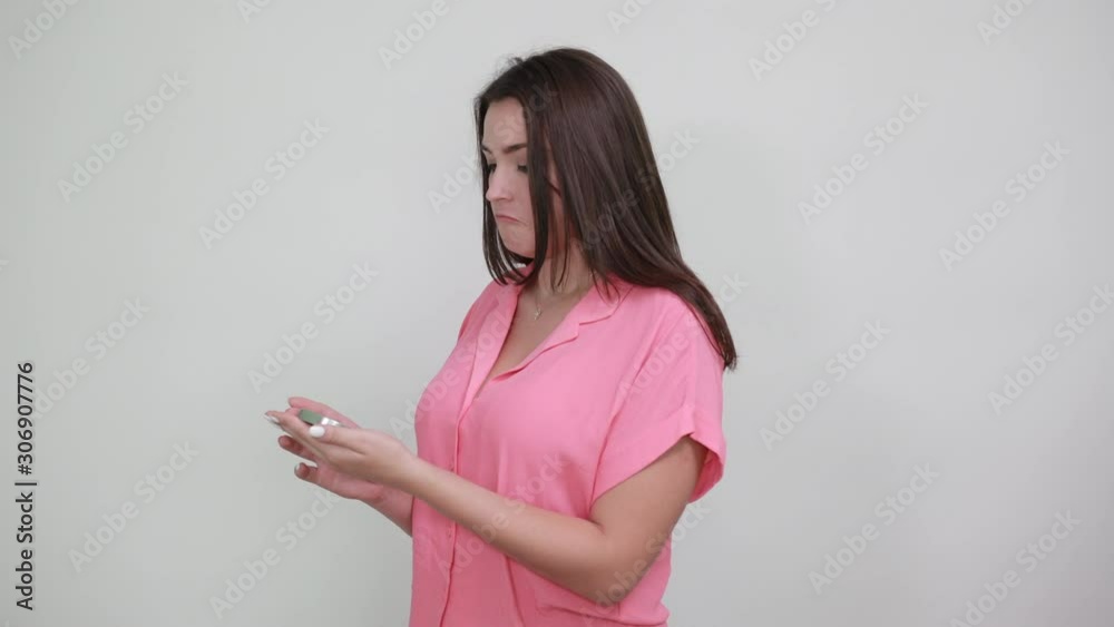 Attractive brunette young woman in pink shirt isolated on white background in studio keeping compass, holding thumbs up. People sincere emotions, lifestyle concept. Attractive brunette young woman in pink shirt isolated on white background in studio keeping compass, holding thumbs up. People sincere emotions, lifestyle concept.